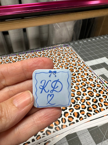 Square Shaped Pin Back Button KD Light Blue Background with Coquette Frame
