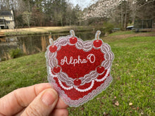 Load image into Gallery viewer, Sticker | AOP_C | Alpha Omicron Pi Heart Shaped Cake | Waterproof Vinyl Sticker | White | Clear | Permanent | Removable | Window Cling | Glitter | Holographic